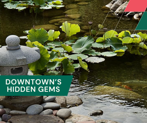 a garden pond with a stone sculpture
