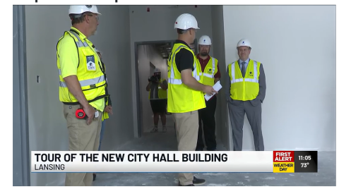 Mayor Andy Schor and others tour the new City Hall building downtown, wearing protective clothing. 