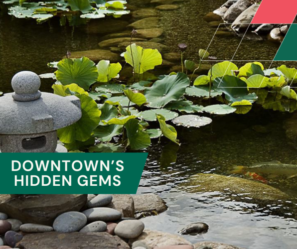 a garden pond with a stone sculpture