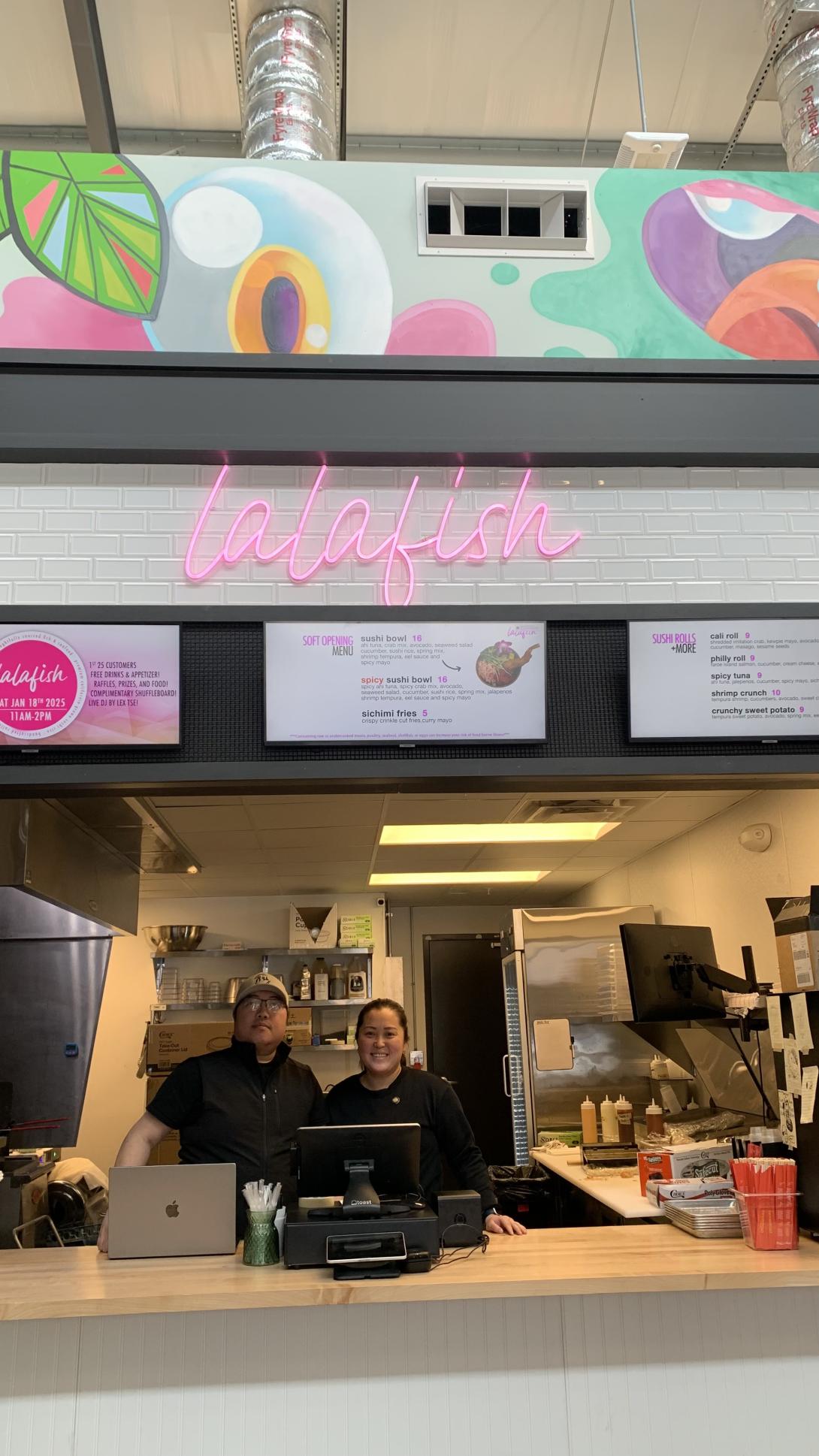 Lalfish founders posing in front of signage